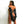 Load image into Gallery viewer, A nude brunette woman is shown from behind in front of a blank background. She wears the Bondage Opera Gloves, which are padlocked together at the hands. A metal snap hook also connects her arms together from the gloves’ D-rings.
