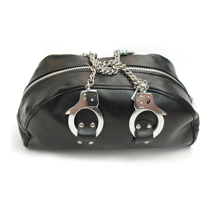 The Leather Doctor Bag with Handcuff Handles is shown against a blank background. It is a black leather bag shaped like a semi-circle. It has a metal zipper on top and chain-link handcuffs as handles.