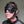 Load image into Gallery viewer, A close-up of a man&#39;s head in the Inescapable Head Harness is shown in front of a grey background. The black leather harness goes around the sides of his head and has loops near the ears. It also has an attached blindfold.
