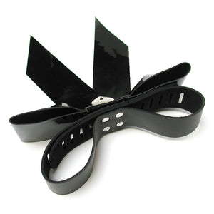 The black Patent Leather Bow Wrist Restraint is shown from the back against a blank background. Behind the bow is a leather loop, closed in the middle to form cuffs.