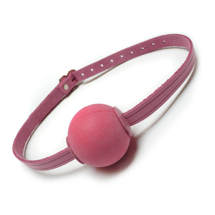 The Pink Ball Gag is shown against a blank background. It is made of a thin strip of light pink leather with a round, matte pink silicone ball in the center.