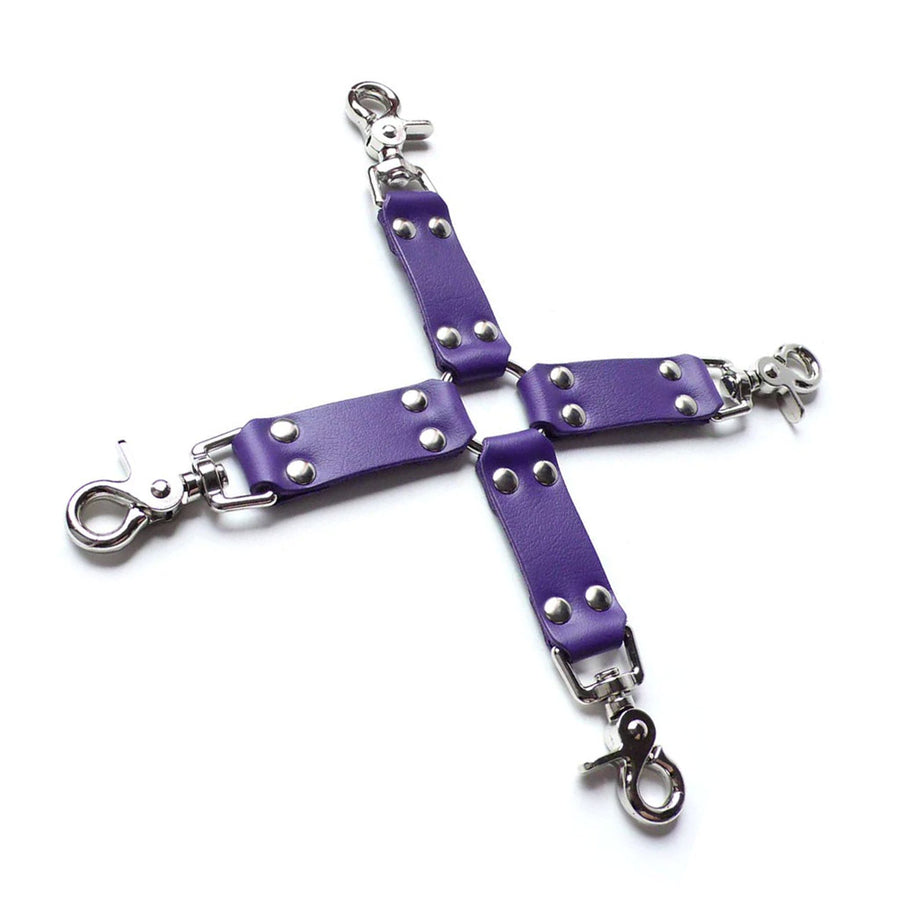 The Purple Leather Hog Tie is displayed against a blank background. The hogtie is made of a metal O-ring in the center with four leather strips attached to it in the shape of an X. Each leather strip has a metal snap hook on the end.