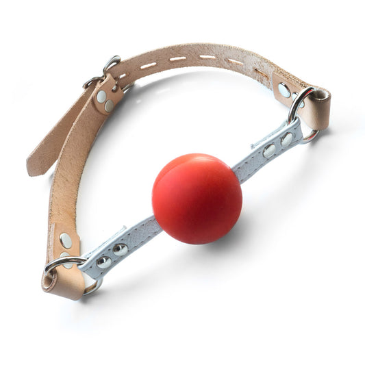 The Medical Silicone Ball Gag is shown against a blank background. The gag is made of a matte red silicone ball with white leather strips on each side. These strips are connected via silver D-rings to an adjustable tan leather strap.