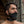 Load image into Gallery viewer, A dark-haired man’s face is shown in front of a stone wall. He has facial hair and is wearing the Over The Mouth Gag With A Silicone Ball and a black collar. The gag has a piece of black leather that completely covers his and a leather strap.
