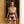 Load image into Gallery viewer, A woman in black panties stands with her arms at her sides in front of a golden wall. She wears the JT Signature Collection Locking Thigh Cuffs and a matching collar, waist and wrist cuffs, which are connected to her waist with matching restraint clips.
