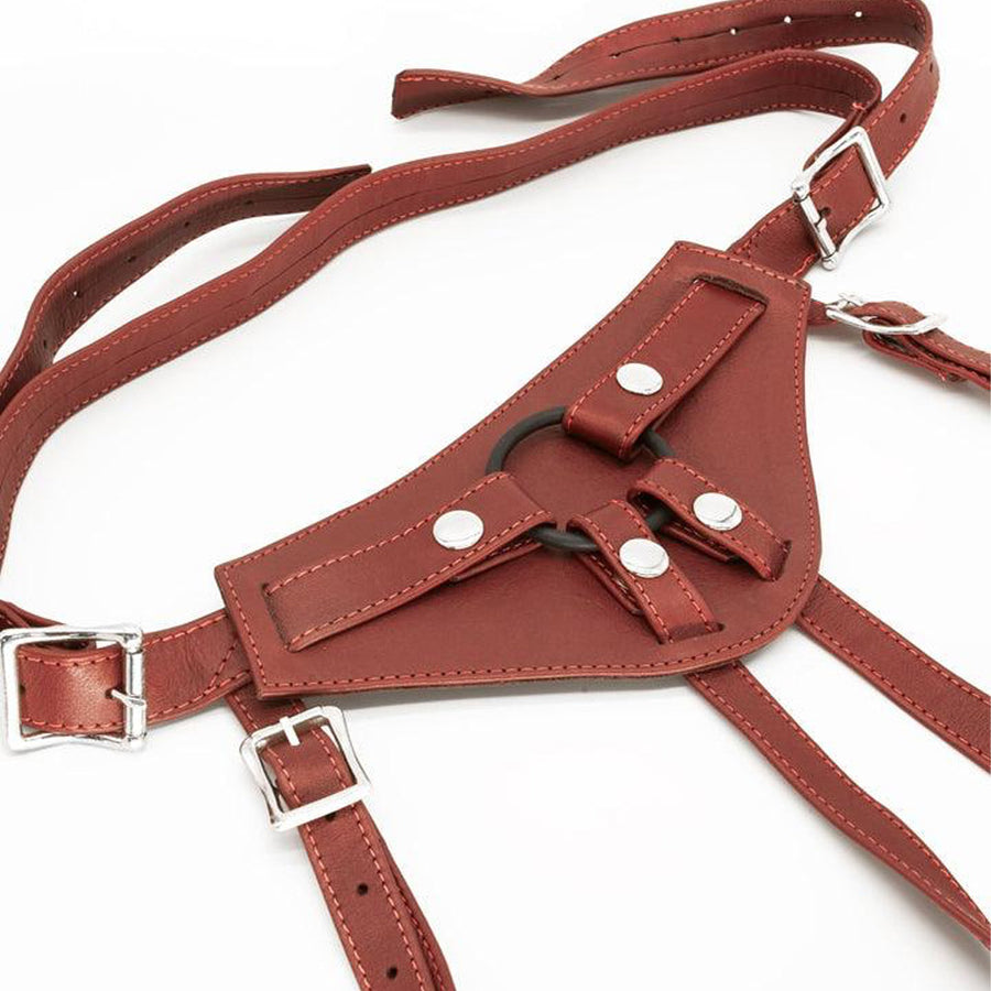 The Full Curves Leather Strap-on Harness in wine is displayed against a blank background. The leather is reddish brown. There is a black silicone O-ring in the center held in place by snap closures.