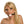 Load image into Gallery viewer, A blonde woman is shown from the shoulders up in front of a blank background. She wears the KinkLab Jawbreaker Gag with black PVC straps. The ball gag is made of a white jawbreaker candy with colorful specks, attached to thin, black, PVC straps.
