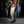 Load image into Gallery viewer, A brunette man with chest hair stands against a wooden beam. He is wrapped from his feet to under his pecs in Clear Latex Bondage Strips, making him resemble a mummy.
