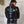 Load image into Gallery viewer, A man standing in front of a white wall wearing the Rubber BDSM Straitjacket is shown from the back. The jacket has a buckle around the neck and on the lower back. There is a metal zipper running up the center of the jacket.
