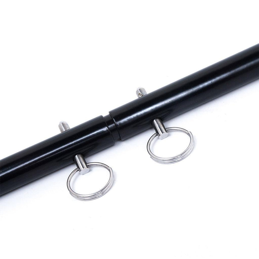 A close-up of the center of the black Adjustable General Purpose Spreader Bar is shown against a blank background. The bar is positioned at the shortest length, with only a slight gap between the two hollow outer bars.