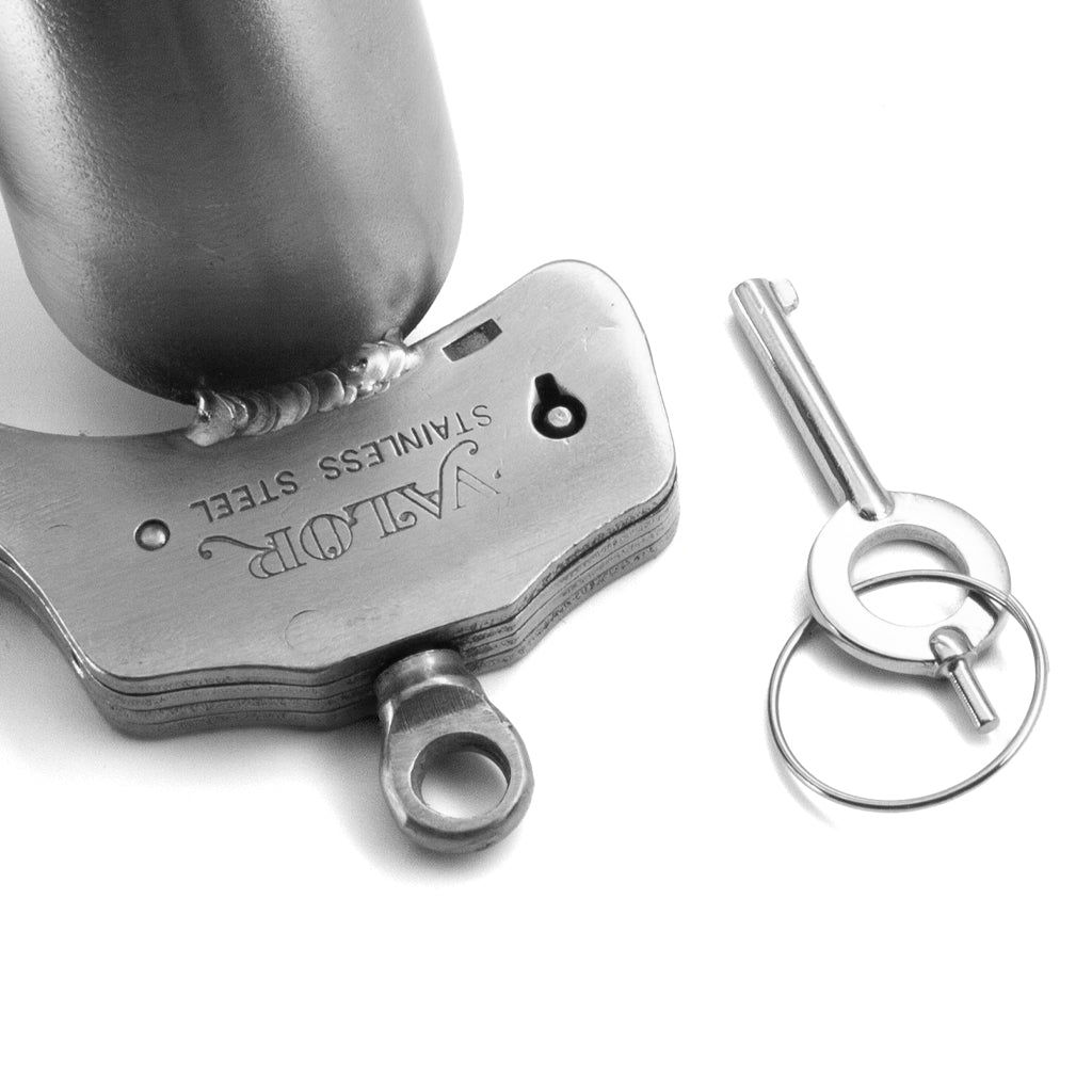 A close up of the lock and key of the Houdini chastity device is shown on a white background.