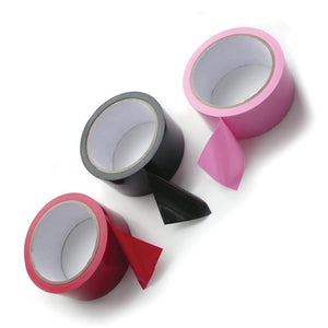 Three roles of Unpackaged Bondage Tape, one of each color, are displayed against a blank background. The roll of tape on the left is red, the one in the middle is black, and the one on the right is pink.