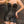 Load image into Gallery viewer, A close-up of a woman&#39;s torso is shown in the Corinthian Corset Dress. The dress laces up at the top across the bust and the thighs and has hook and eye closures across the torso. The garter straps hold up her fishnet stockings.
