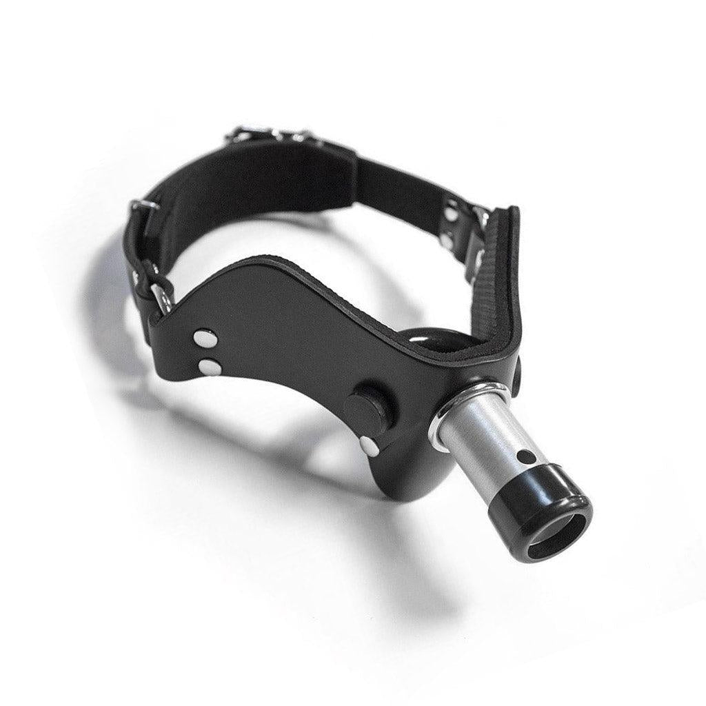 The “How May I Help You?” Gag, A.K.A the Humiliator Gag, is displayed against a blank background. The gag has a padded, black leather V-shaped front with a rounded bit on the inside. A short metal rod protrudes from the center of the gag.  