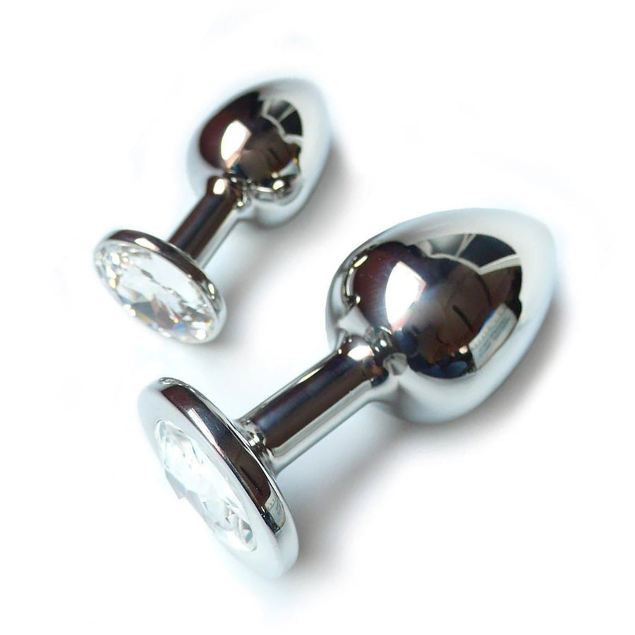 Two Julian Snelling Rosebuds Jeweled Anal Plugs, one medium and one large, are displayed against a blank background. The plug is made of silver metal and is tapered with a thin neck and wide base. The base has a clear Swarovski Crystal covering it.