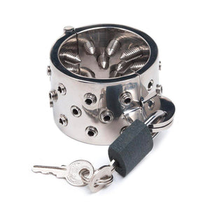 The Mike's Spikes Cock & Ball Torture Device is shown against a blank background. It is a stainless steel cylinder that is smooth on the outside and has many metal spikes on the inside. It is locked shut, and the keys are shown hanging out of the padlock.