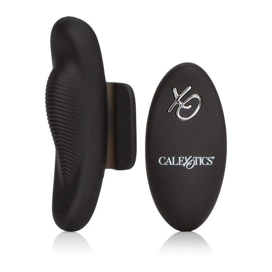 The Lock-N-Play Remote Petite Panty Teaser is shown with its remote against a blank background. The vibrator is matte black and oval-shaped, with a ribbed, raised portion in the middle, and has a piece of black silicone extending from the side.