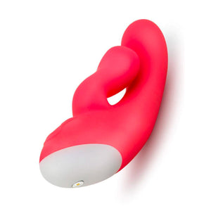 The Cerise Hop Trix Rabbit Vibrator is shown from the bottom against a blank background, showing its magnetic charging port.
