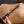 Load image into Gallery viewer, A close-up of a woman’s bare stomach is shown against a grey background. She has a French manicure and holds the Electrastim Depth Charge Electro Dildo on her stomach.
