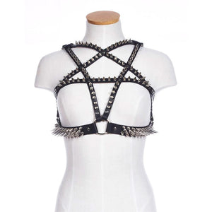 The black leather Spiked Pentagram Bust Harness is displayed on a female mannequin. The harness has an underbust strap connected to the pentagram with an O-ring. All straps on the harness are lined with silver metal spikes.