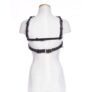 The back of the black leather Spiked Pentagram Bust Harness is displayed on a female mannequin. There are two horizontal buckling straps across the upper back, one thick and one thin. The thicker strap has metal studs.