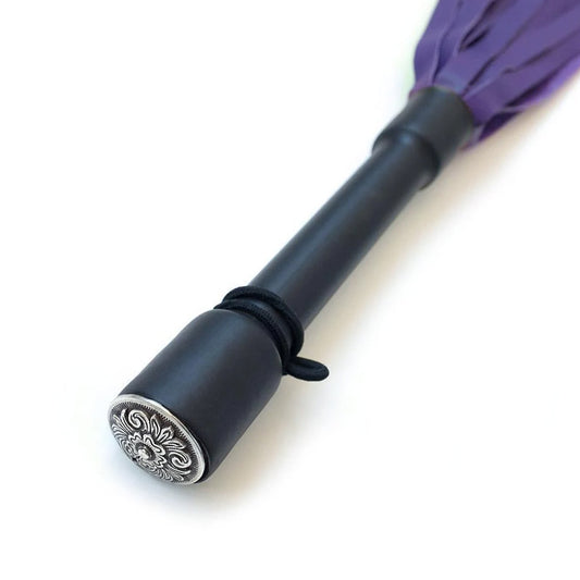 A close-up of the Purple Devil Leather Flogger By Dragontailz handle is displayed against a blank background, showing the silver ornamental cap on the end of the handle. 