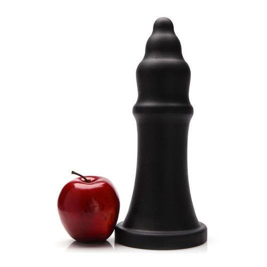 The black Tantus The Queen XL Silicone Dildo is shown next to a red apple agaist a white background.