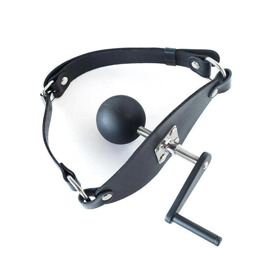 The Screw Ball Mouth Gag is shown against a blank background. It has a buckling leather strap with a flat piece of black leather and a metal plate in the front, which holds a metal crank with a handle on the outside and a black silicone ball on the inside.