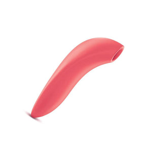 The We-Vibe Melt Pleasure Air Clitoral Vibrator in Coral is shown from the side against a blank background. The toy has a straight handle a sligtly curved top, where there is a hole.