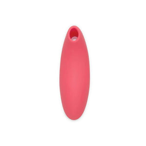  The We-Vibe Melt Pleasure Air Clitoral Vibrator in Coral is shown next to a cell phone against a blank background. The cell phone screen shows the app that can be used to control the toy.