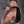 Load image into Gallery viewer, A man is shown from the side standing in front of a metal wall. He is nude except for a black latex jock, and is holding the 24&quot; Basic Suede Flogger over his shoulder.

