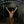 Load image into Gallery viewer, A nude woman with her hair pulled back stands in the entranceway to a tunnel. She wears the black leather Deluxe Suspension Cuffs, which are attached to black leather straps. The straps wrap around the top of the iron doorway, pulling her arms upwards and outwards.
