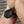 Load image into Gallery viewer, A man’s penis inside of the Penis Prison With Pin Prick Lining and a Leather Cock Strap is shown. The pouch is a small, black leather pouch that zippers on the bottom. It has a black leather cock strap at the base and is secured by a brass padlock.
