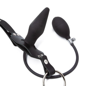 A close-up product shot of the Inflatable Anal Plug Harness for Men on a white background. It is a leather harness made by The Stockroom.