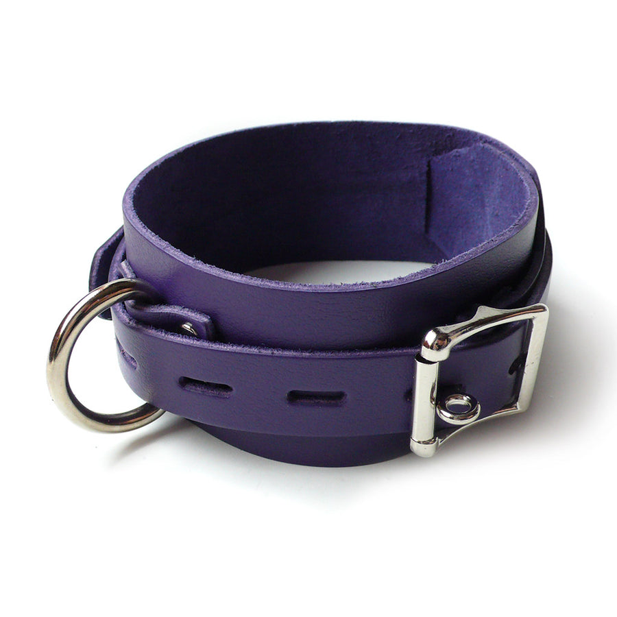 The Purple Leather Collar with a Locking Buckle is shown against a blank background. The collar is a wide piece of purple leather with a narrower, notched strip of leather wrapped over it. It has a silver D-ring and buckle.