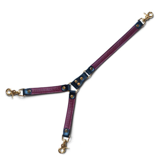 The JT Signature Collection Tether is shown against a blank background. It is made of leather strips in an upsidedown Y shape, connected with brass hardware. The leather is Bordeaux colored with black accents.