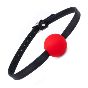 The red Silicone Ball Gag With A Garment Leather Strap is displayed against a blank background. It is a medium-sized bright red ball made of matte silicone with a thin, adjustable black leather strap.