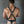 Load image into Gallery viewer, A muscular man with dark hair in a black leather thong is shown from the back in front of a metal wall. He wears the Butcher Tank Harness, which has four adjustable leather straps in the shape of an &#39;X,&#39; connected by a metal O-ring, in the back.
