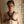 Load image into Gallery viewer, A shirtless brunette man is shown from the waist upwards, standing in front of a white brick wall. He wears the Garment Leather Chest Harness. A strap goes over each shoulder and under his arms. They are attached in the middle to a metal O-ring.
