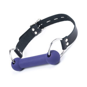 The Silicone Bit Gag in purple is displayed against a blank background. The bit is purple, and the straps are black.