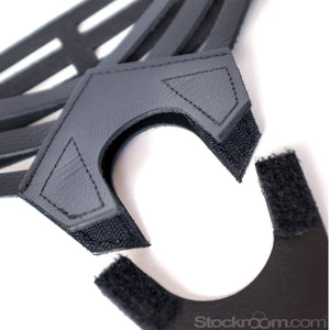 A closeup of the front pieces of the black leather Vanity Strapon Dildo Harness is shown against a blank background. The pieces are unattached, showing the velcro.