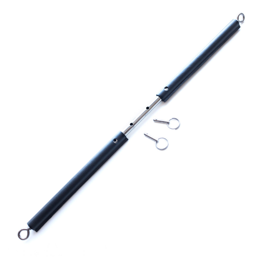 The black Leather Wrap General Purpose Spreader Bar is shown elongated against a blank background. The pins are removed, revealing the four holes that the pins can be placed into to create different lengths.