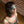 Load image into Gallery viewer, A close-up of a woman with a black bob haircut is shown. She is kneeling on the floor of a brick room and wearing a black bra, as well as a black collar with red lacing. She is wearing the Foam Padded Aviator Blindfold, made of black leather.
