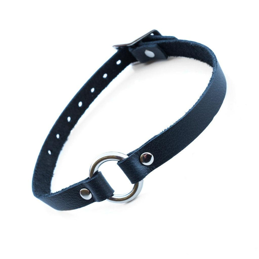 A black O-Ring Leather Choker is displayed against a blank background. The collar has a thin band of black leather with a small O-Ring in the center. The hardware is silver metal.