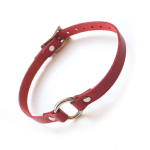 A red O-Ring Leather Choker is displayed against a blank background. The collar has a thin band of red leather with a small O-Ring in the center. The hardware is silver metal.