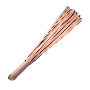 The Stupid Cute Baby Pink Leather Flogger is shown against a blank background. The handle is smooth, cylindrical, and the same color leather as the falls. There is a small loop at the base of the handle.