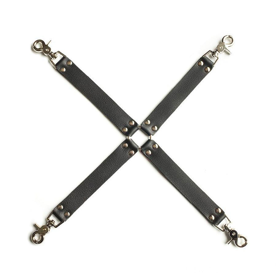 The Bondage Full Curves Leather Hog Tie Four Point Restraint is shown against a blank background. It is made of 4 black leather strips arranged in an X shape, connected in the middle by a metal O-ring. Each leather strip has a snap hook on the end.