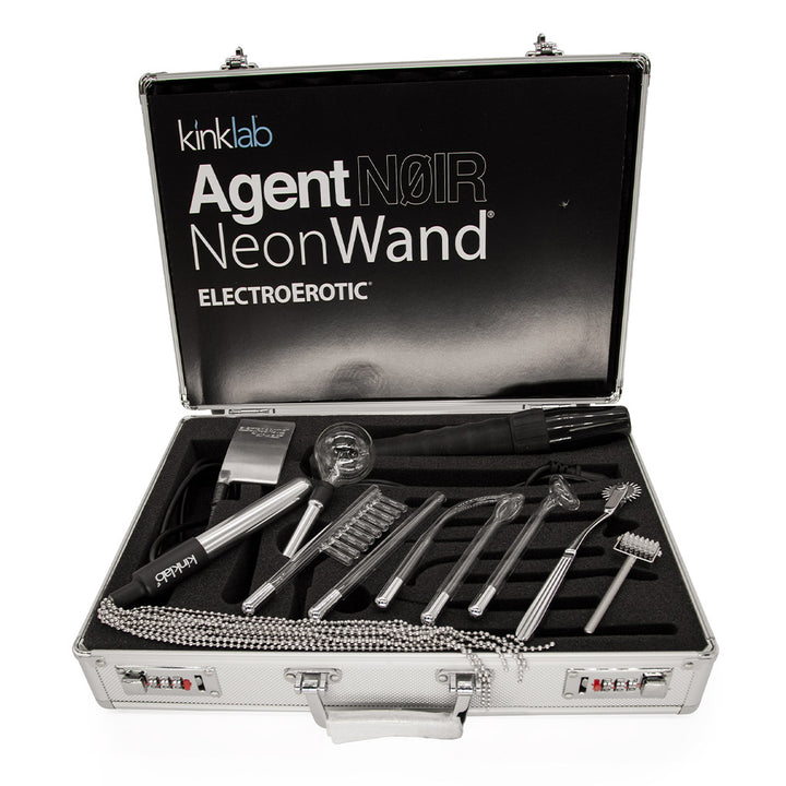 The interior of the Kinklab Agent Noir™ Neon Wand Electrosex Kit case is shown against a blank background. The interior of the case is padded with black foam with individual cutouts for the wand and each attachment.