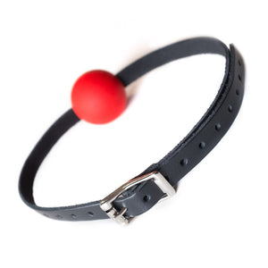 The Kinklab Red Silicone Ball Gag With A Leather Strap is displayed from the back against a blank background, showing the adjustable metal buckle.