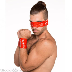 A nude man with dark hair is shown against a blank background. His arms are pulled together in front of him, and his wrists are wrapped together with red Kinklab Bondage Tape. He also has a piece of tape wrapped around his head, covering his eyes.